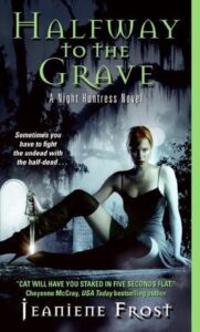  Book cover for "Halfway to the Grave" by Jeaniene Frost, showing a woman in tall boots sitting on a tombstone, holding a dagger in a dark, graveyard setting.