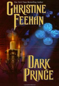 Book cover for the vampire book "Dark Prince" by Christine Feehan, featuring a lit candelabra on the left and glowing blue, floral shapes in the dark background.