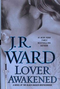 Black and white book cover for "Lover Awakened" by J.R. Ward, showing a couple embracing and the hilt of a sword.